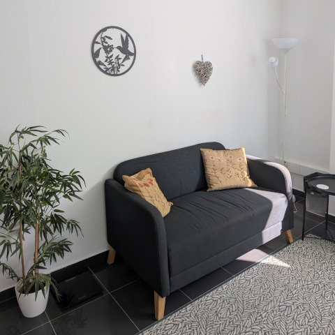 Sala de atendimento da PsiEquilibra com sofá, planta e decoração acolhedora